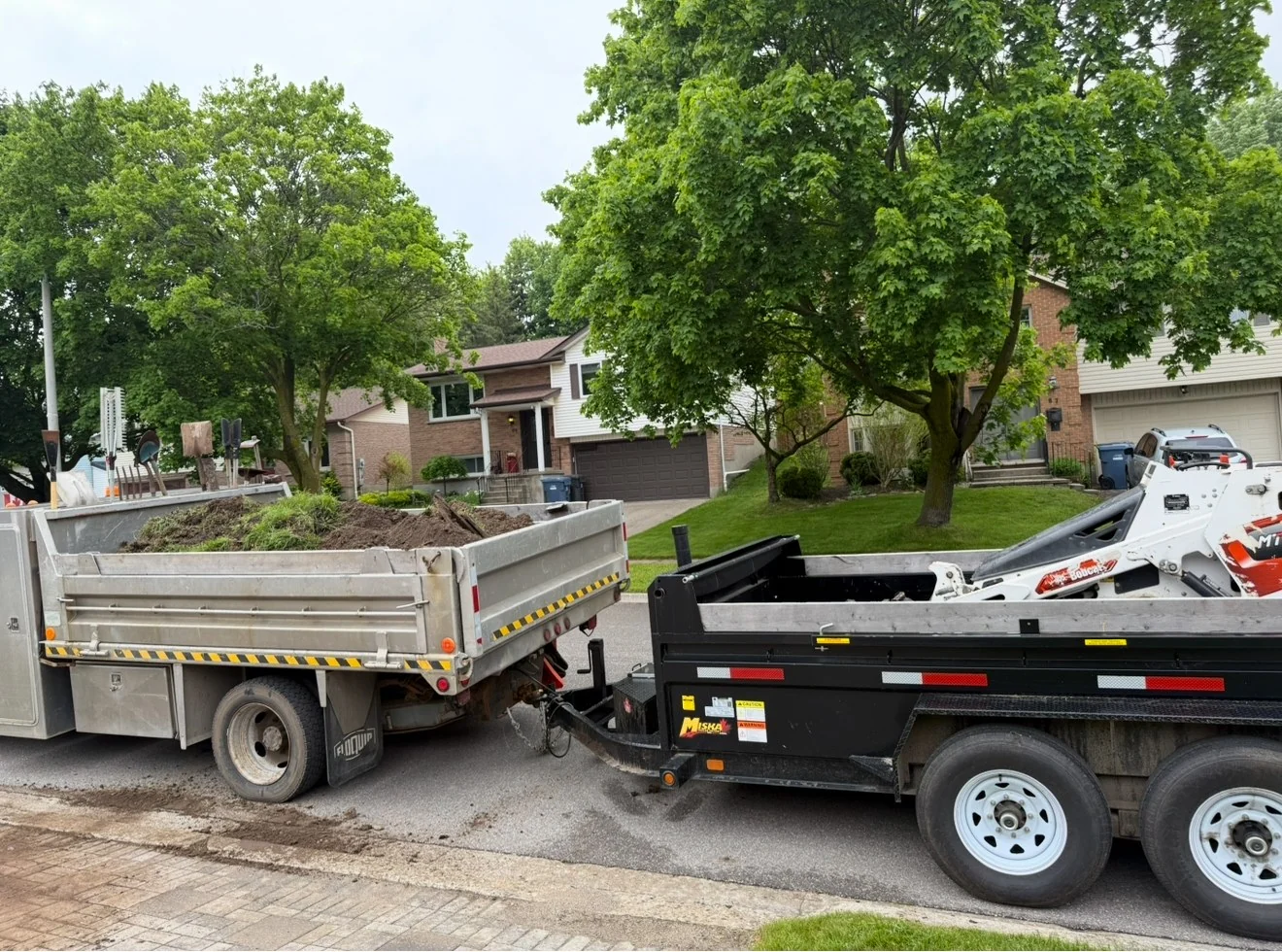 NS Services dump truck and trailer hauling material for a commercial job